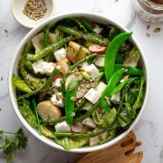 Potatoes, peas, feta, radish and asparagus with lettuce in a bowl