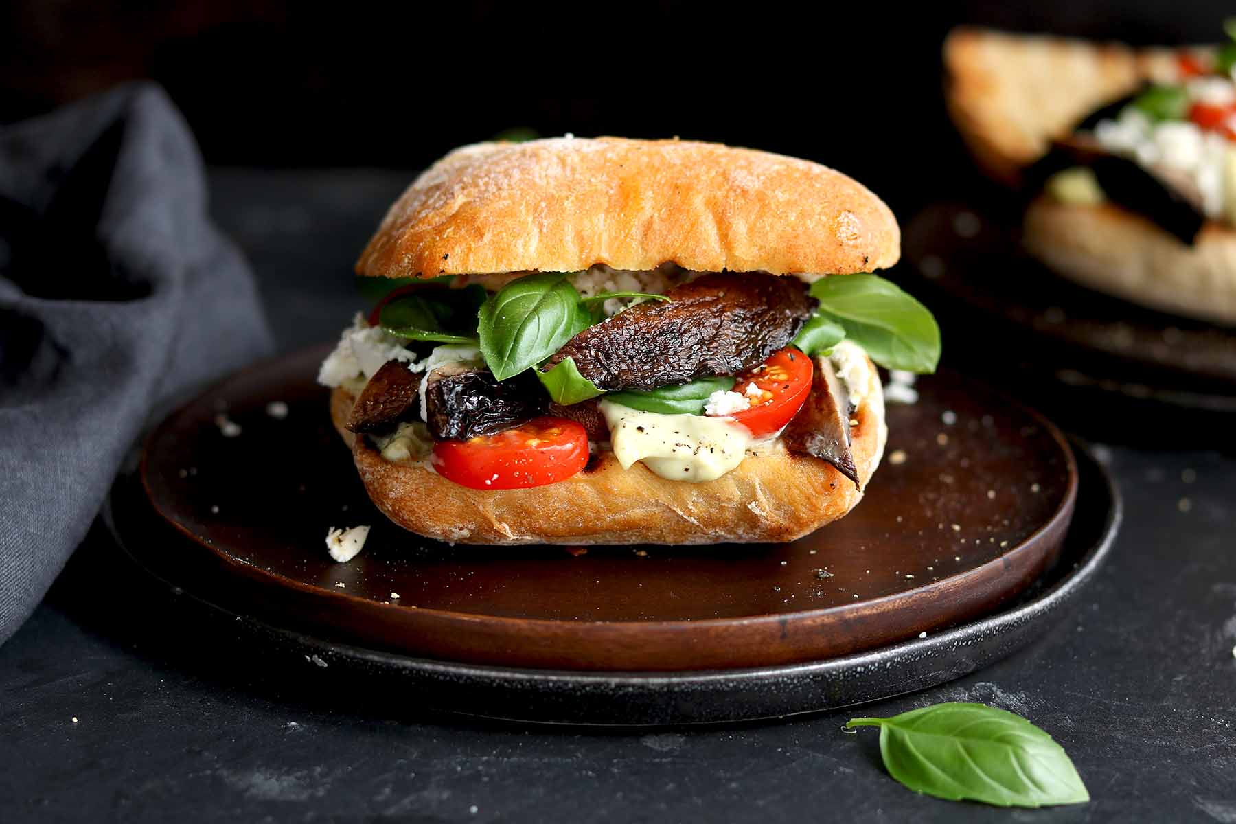 portobello mushroom sandwich with basil on a plate