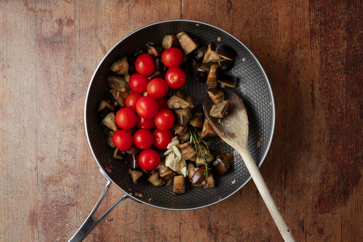 aubergine cooking in pan with tomatoes