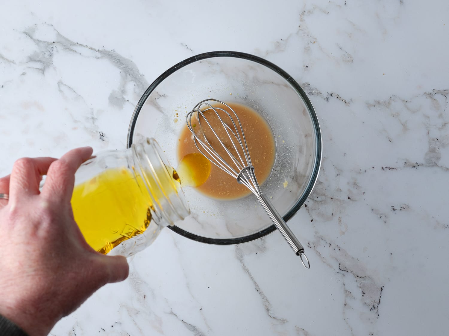 dressing within a bowl with oil pour